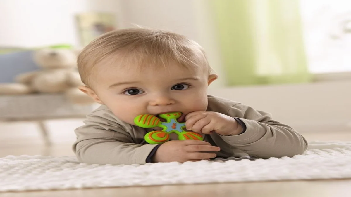 Teething Woes a baby lying on the floor with a toy in its mouth